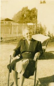 Gertrude Pusch Zipf Sitting in Chair in Yard with White Fence