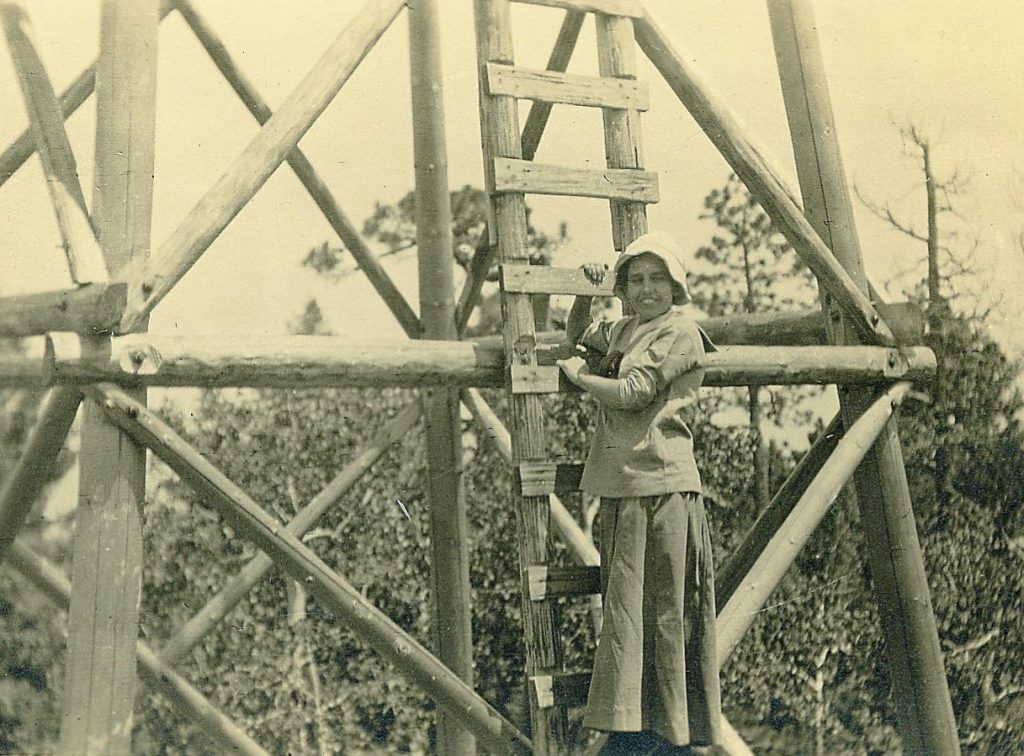Gertrude in Bonnet on Ladder on Lemmon Rock Lookout Tower