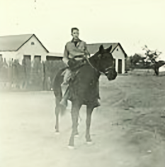Cowboy on Horse in Front of Bunkhouses