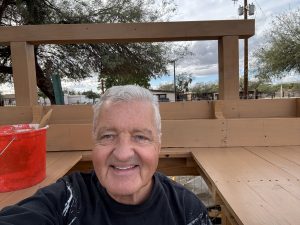 Bob Keller Staining the Potter's Bench for the Heritage Garden_November 2025 on a cold day - he's wearing a jacket