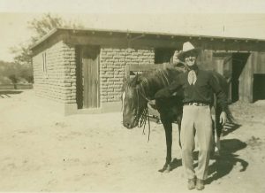 Jack Procter with Horse in Front of Horse Barn