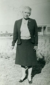 Gertrude Pusch-Zipf in Skirt and Sweater in Front of a House