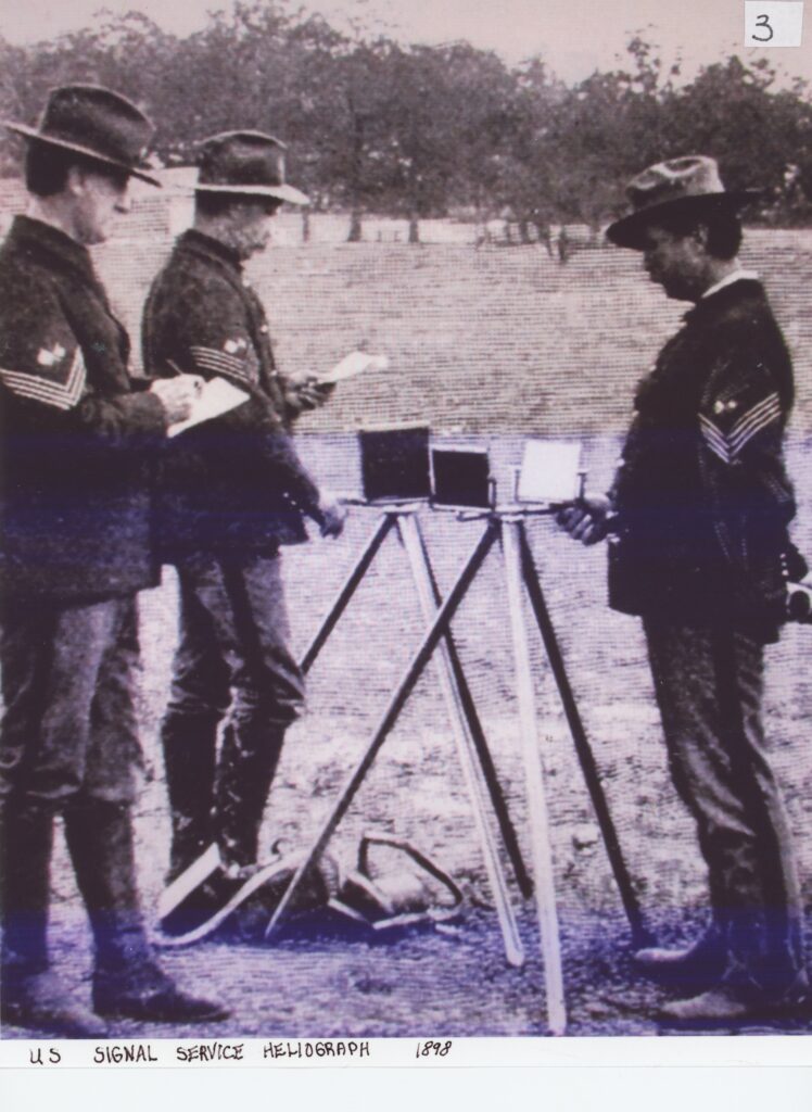 3 uniformed soldiers standing around a US Signal Serviced Heliograph 1898